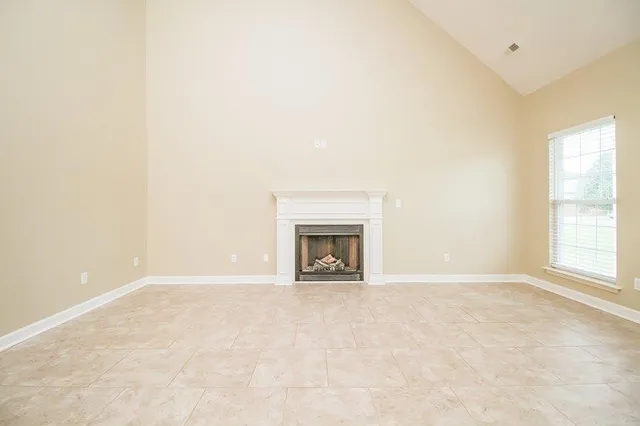 an empty room with a fireplace and a window