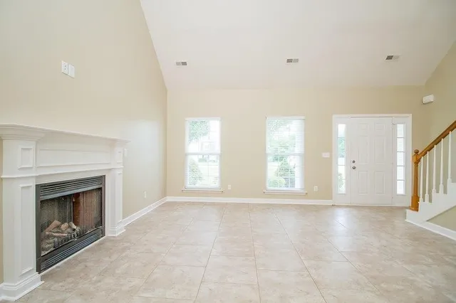 a view of an empty room with a fireplace and a window