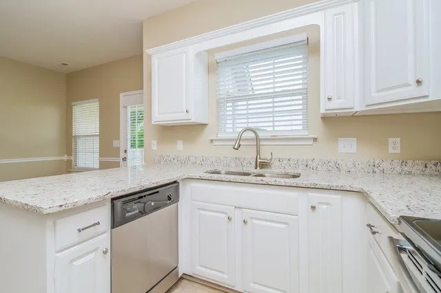 a kitchen with granite countertop white cabinets and white appliances