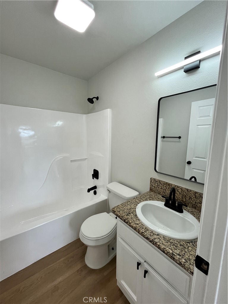 1004 South Riverside Avenue, Unit C1 Rialto, CA 92376 - Photo 15 of 19 a bathroom with a granite countertop sink mirror vanity and toilet
