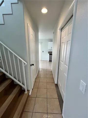 a view of a hallway with wooden floor cabinets and a kitchen