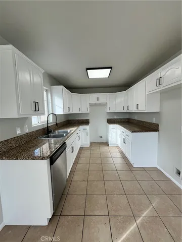 a large kitchen with stainless steel appliances granite countertop a stove top oven a sink a counter space and cabinets