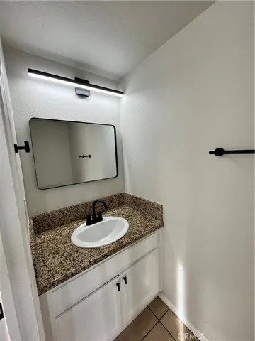a bathroom with a granite countertop sink and a mirror