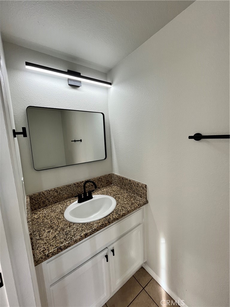 1004 South Riverside Avenue, Unit C1 Rialto, CA 92376 - Photo 9 of 19 a bathroom with a granite countertop sink and a mirror