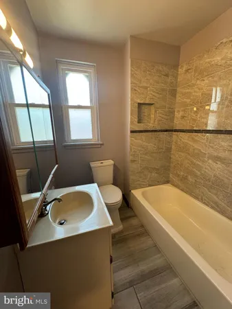 a bathroom with a tub a sink and a window