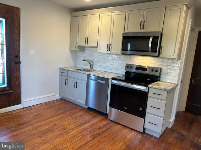 a kitchen with stainless steel appliances granite countertop a stove a microwave and a refrigerator