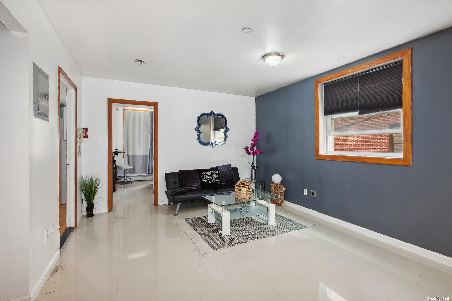 42-38 Judge Street, Unit 2A Queens, NY 11373 - Photo 2 of 14 a living room with furniture and a painting on the wall