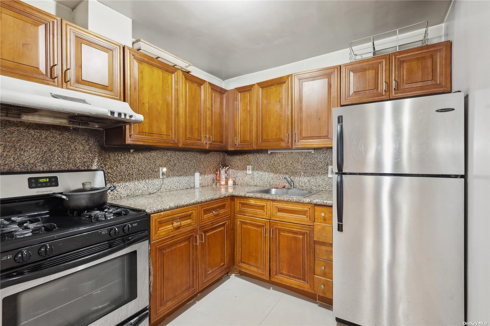 42-38 Judge Street, Unit 2A Queens, NY 11373 - Photo 5 of 14 a kitchen with stainless steel appliances granite countertop a refrigerator stove sink and cabinets