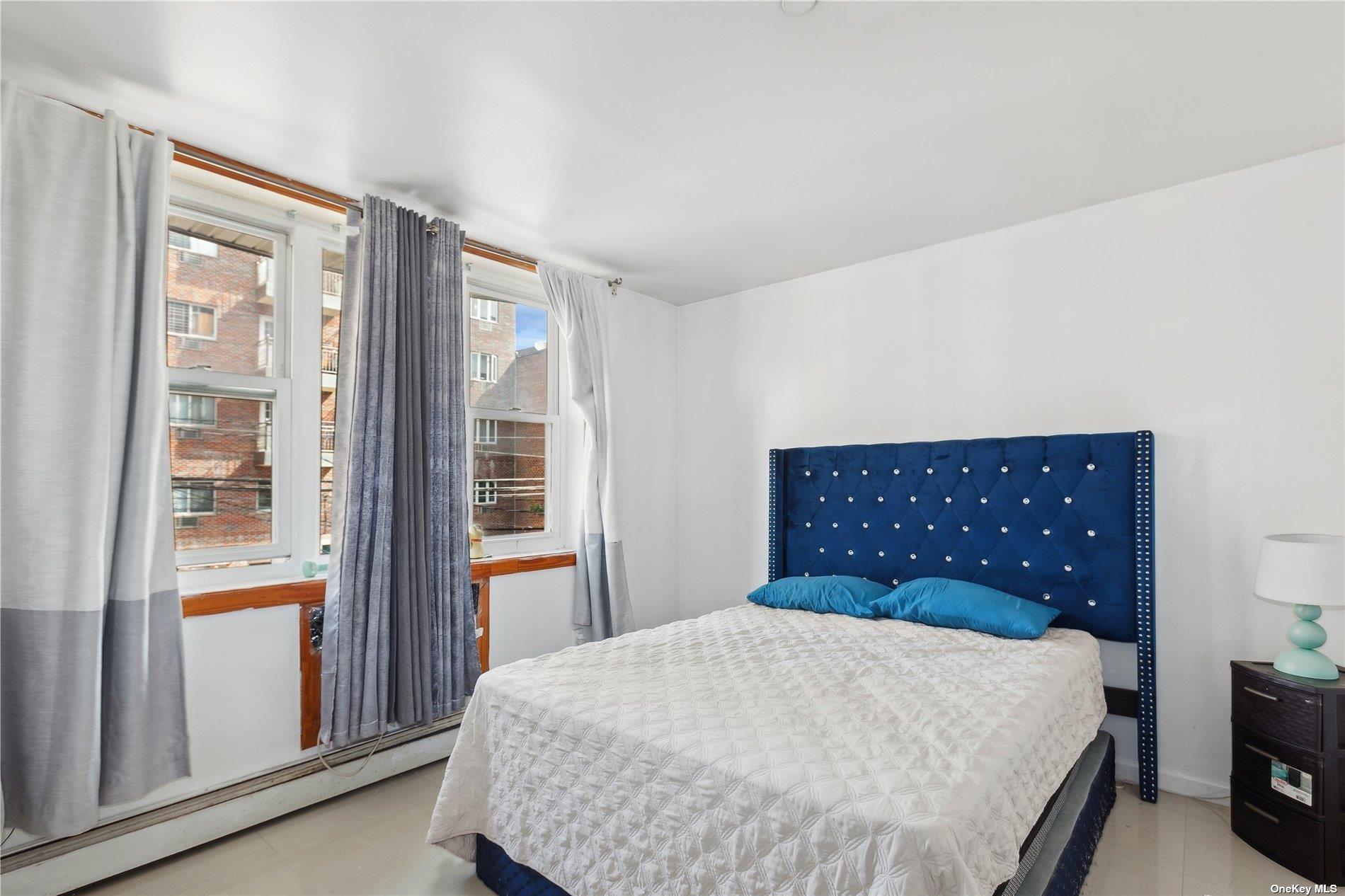 42-38 Judge Street, Unit 2A Queens, NY 11373 - Photo 7 of 14 a bedroom with a large bed and a large window