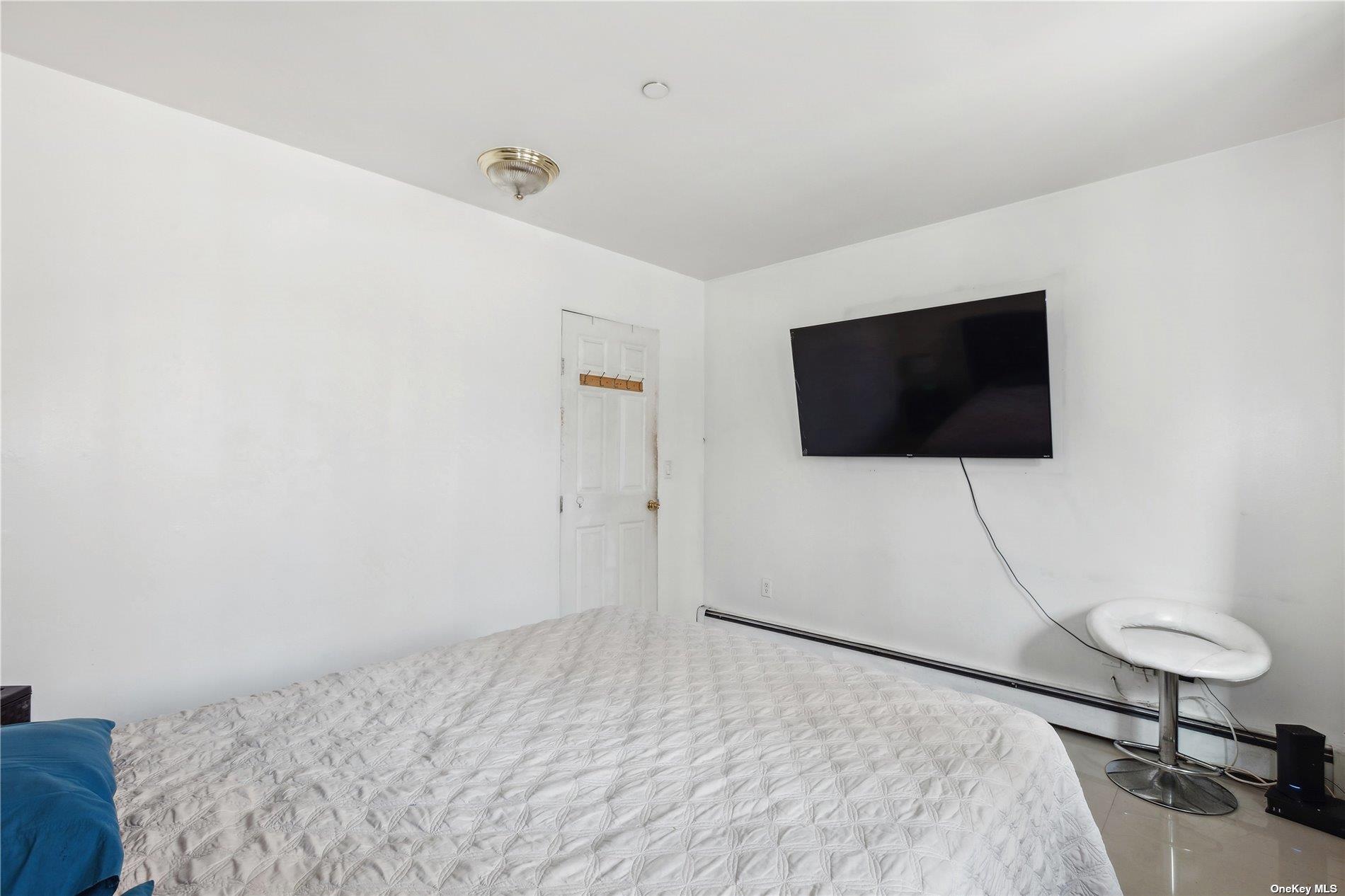 42-38 Judge Street, Unit 2A Queens, NY 11373 - Photo 8 of 14 a bedroom with a bed and a flat screen tv