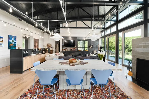 a view of a dining room with furniture a fireplace and wooden floor