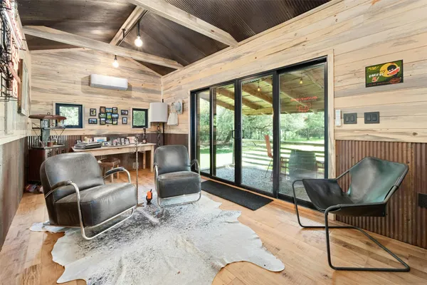 a living room with furniture a flat screen tv and a floor to ceiling window