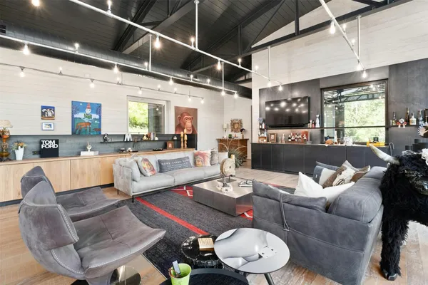 a living room with furniture kitchen view and a large window
