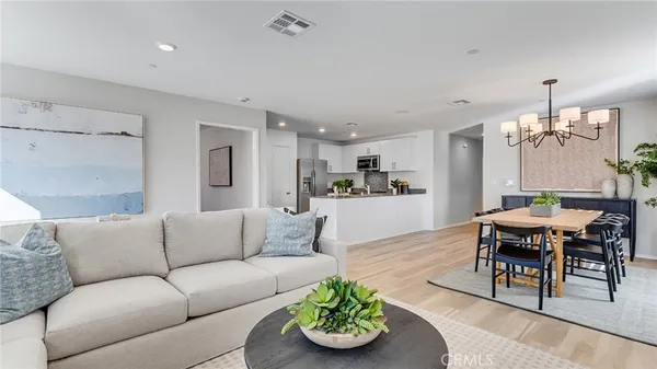a living room with furniture kitchen view and a dining table