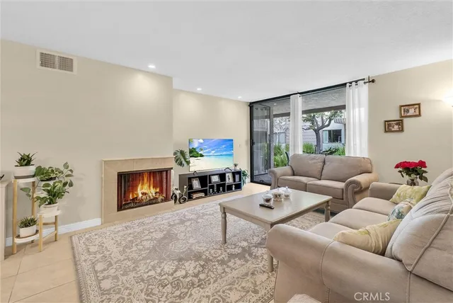 a living room with furniture a fireplace and a flat screen tv