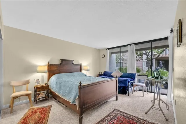 a bedroom with a bed and large windows