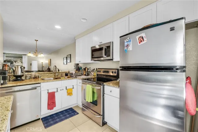 a kitchen with kitchen island granite countertop stainless steel appliances and sink