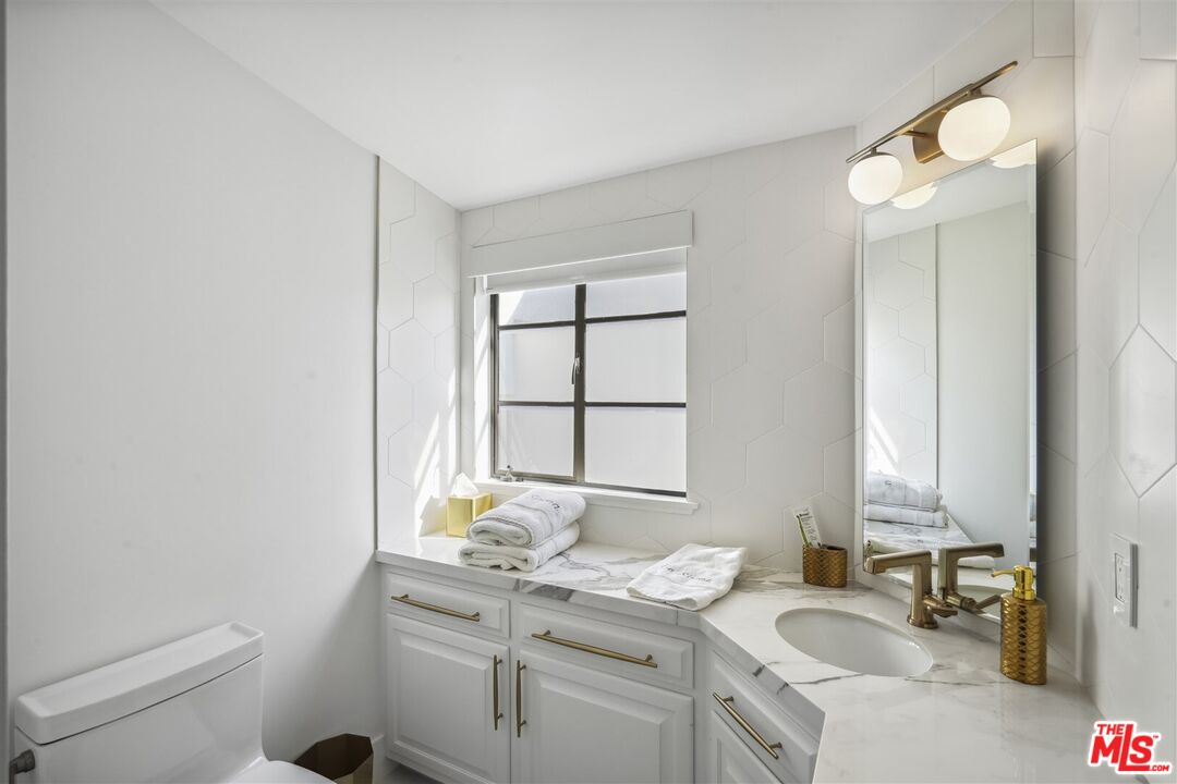 31500 Victoria Point Road Malibu, CA 90265 - Photo 44 of 53 a bathroom with a granite countertop sink toilet and mirror