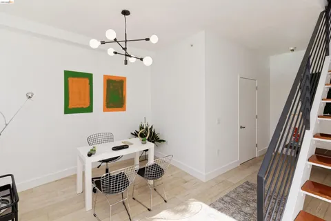 a dining room with chandelier and wooden floor