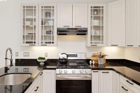a kitchen with stainless steel appliances granite countertop a sink stove and cabinets