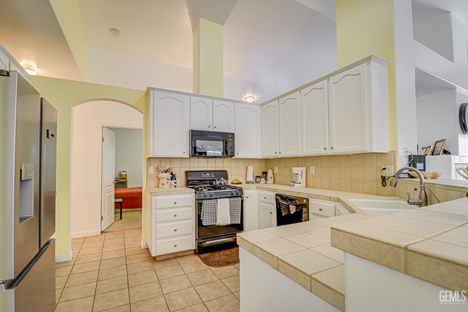 Undisclosed Address Bakersfield, CA 93311 - Photo 15 of 31 a kitchen with a stove a sink and a refrigerator