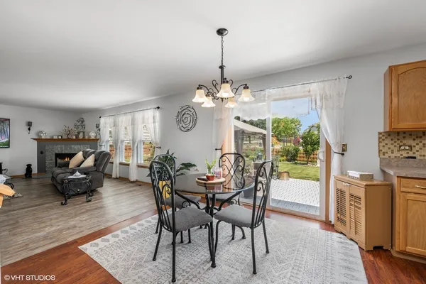 a dining room with furniture a chandelier and wooden floor