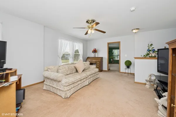 a living room with furniture a flat screen tv and a window