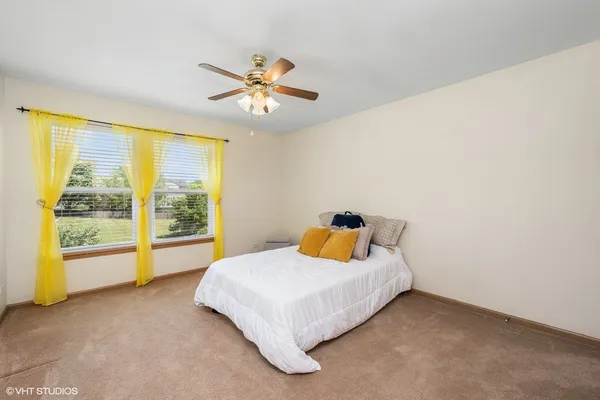 a bedroom with a bed and ceiling fan