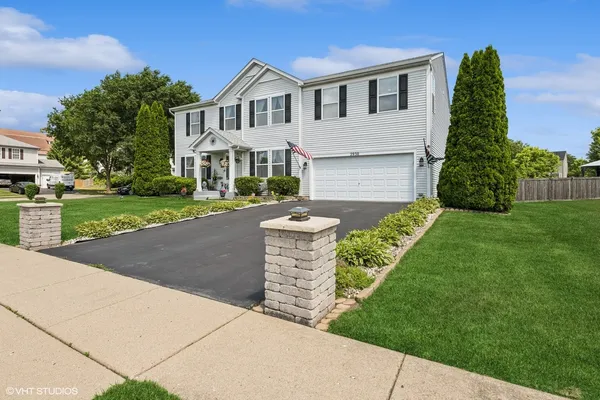 a front view of a house with a yard and garage