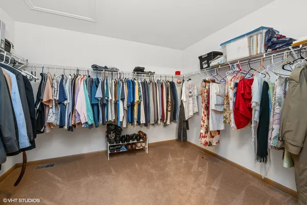 a view of walk in closet with clothes