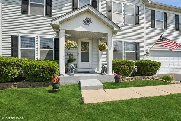 a front view of a house with a yard and plants