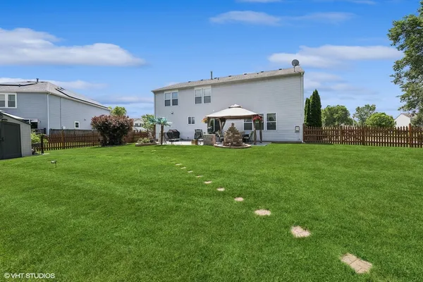 a view of a house with a big yard and a large tree