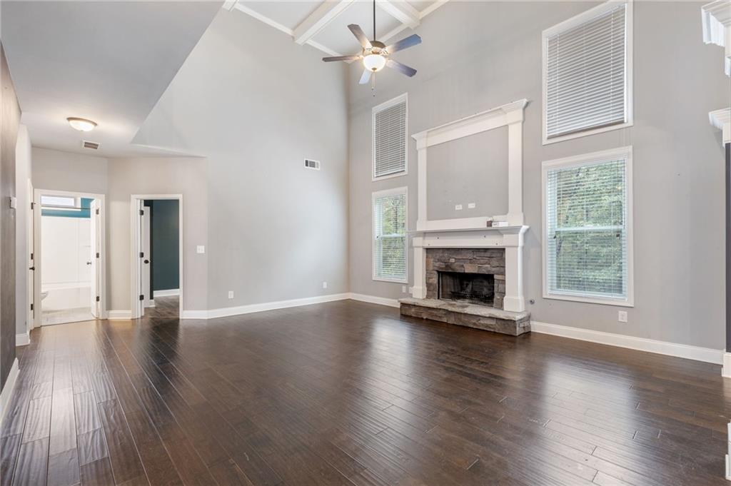1023 Ruddy Duck Drive Jefferson, GA 30549 - Photo 14 of 69 an empty room with wooden floor a fireplace a ceiling fan and windows