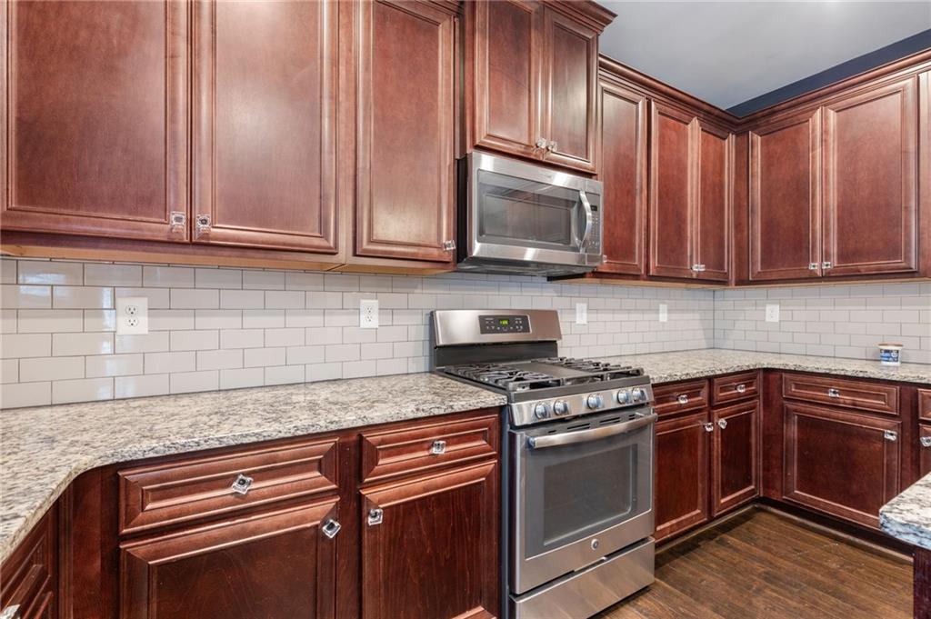 1023 Ruddy Duck Drive Jefferson, GA 30549 - Photo 22 of 69 a kitchen with granite countertop cabinets stainless steel appliances and wooden cabinets