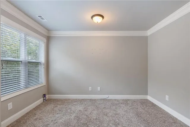 an empty room with wooden floor cabinet and windows