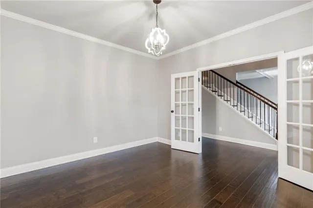 an empty room with wooden floor a fireplace a ceiling fan and windows
