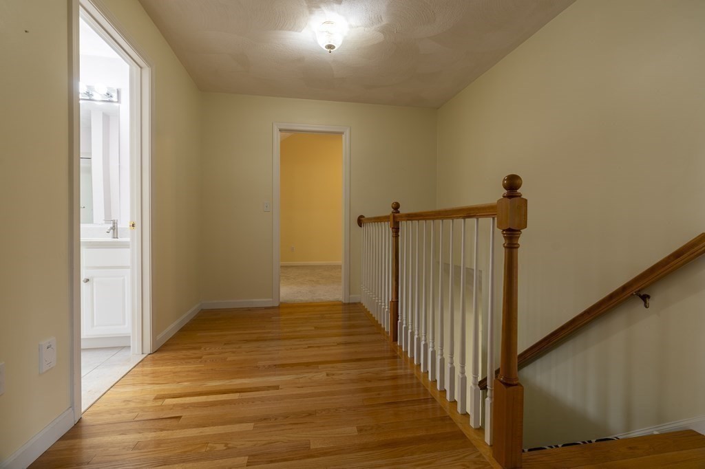 31 Hickory Lane Hudson, MA 01749 - Photo 13 of 40 a view of a hallway with wooden floor and staircase