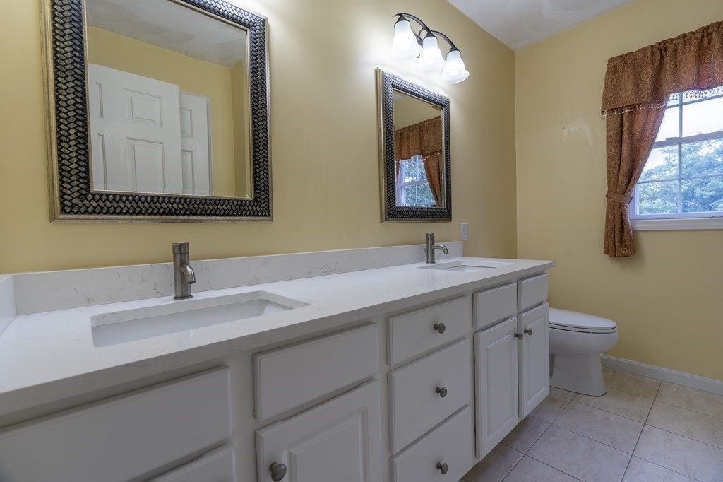 31 Hickory Lane Hudson, MA 01749 - Photo 16 of 40 a bathroom with a toilet sink and mirror