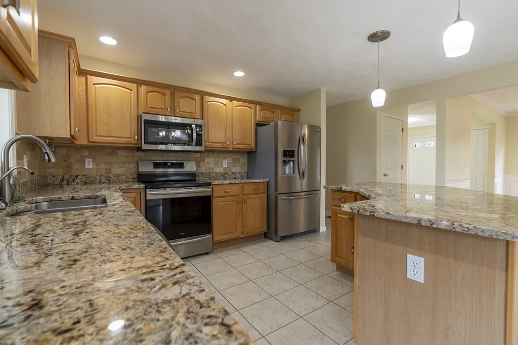 31 Hickory Lane Hudson, MA 01749 - Photo 9 of 40 a kitchen with stainless steel appliances granite countertop a sink stove and refrigerator