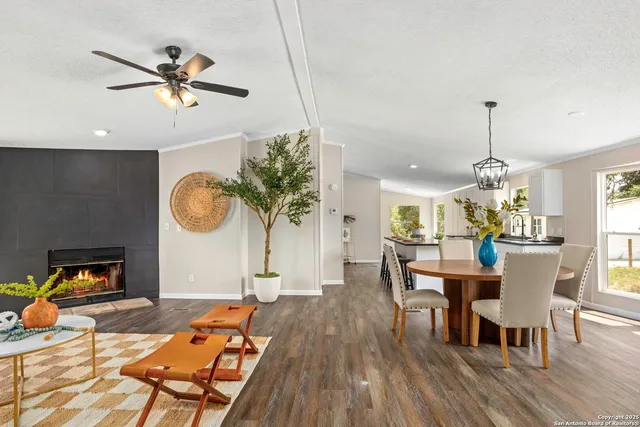 a dining room with wooden floor a chandelier a wooden table and chairs