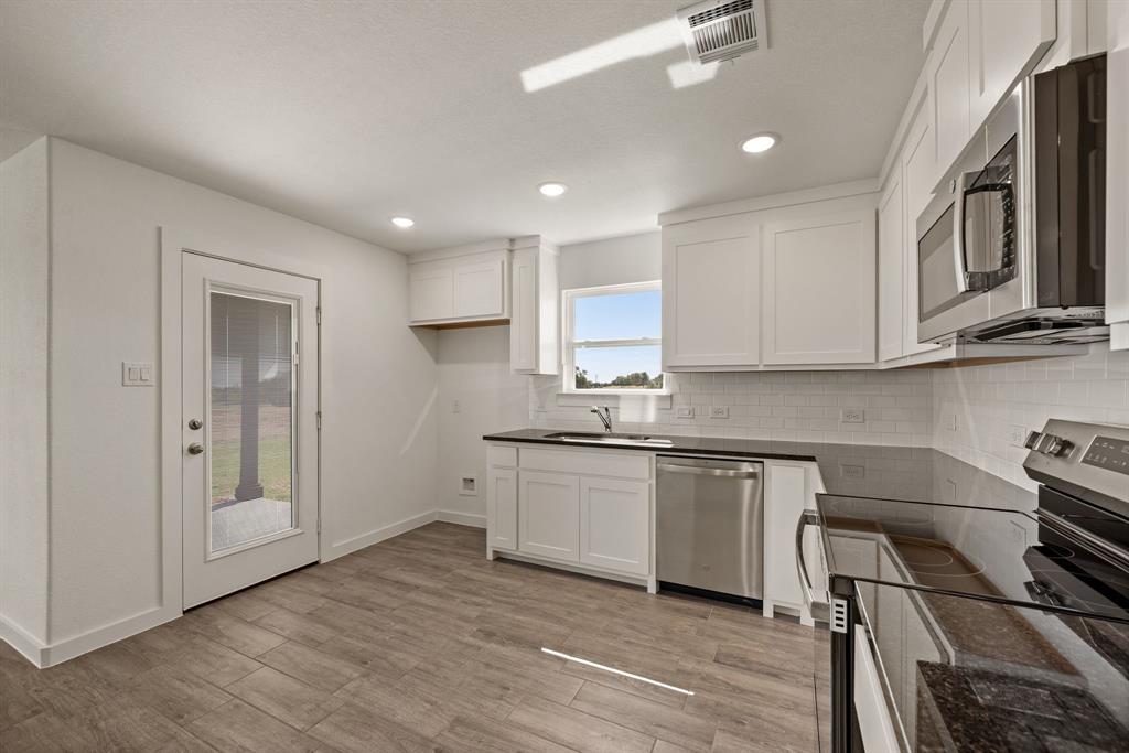 1016 Gatlin Circle Springtown, TX 76082 - Photo 14 of 30 a kitchen with stainless steel appliances granite countertop a stove and a sink