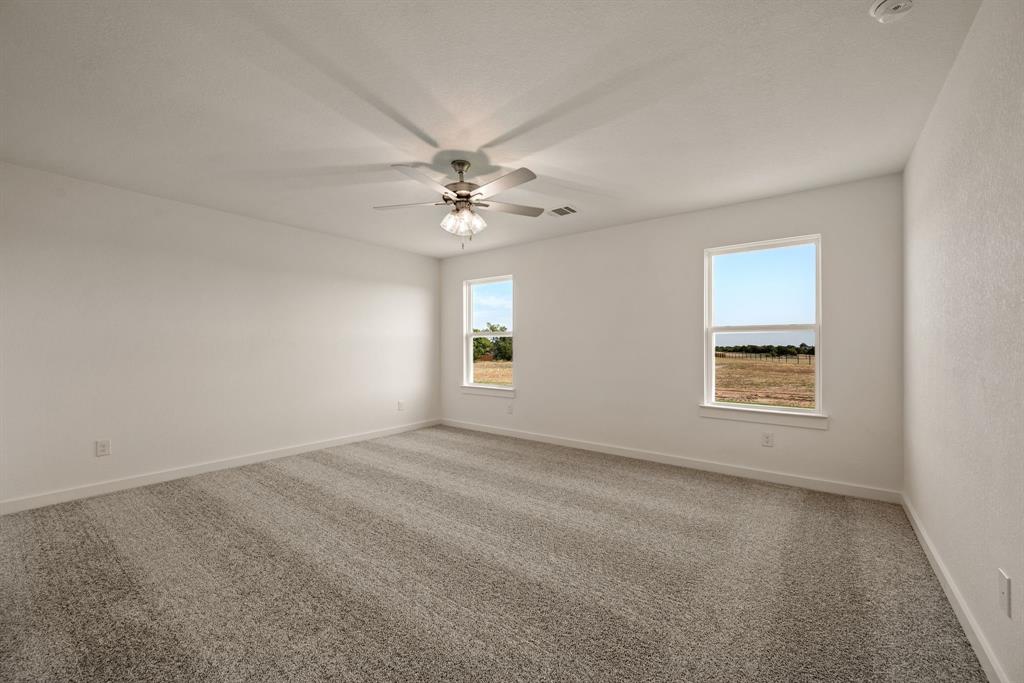 1016 Gatlin Circle Springtown, TX 76082 - Photo 18 of 30 an empty room with a window and a ceiling fan