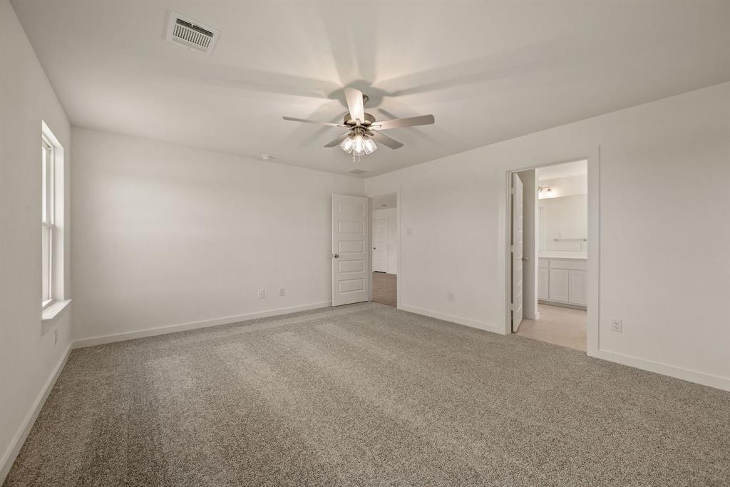 1016 Gatlin Circle Springtown, TX 76082 - Photo 19 of 30 an empty room with a chandelier fan and windows
