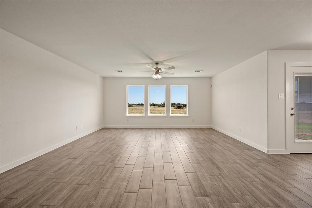 1016 Gatlin Circle Springtown, TX 76082 - Photo 9 of 30 wooden floor in an empty room with a window