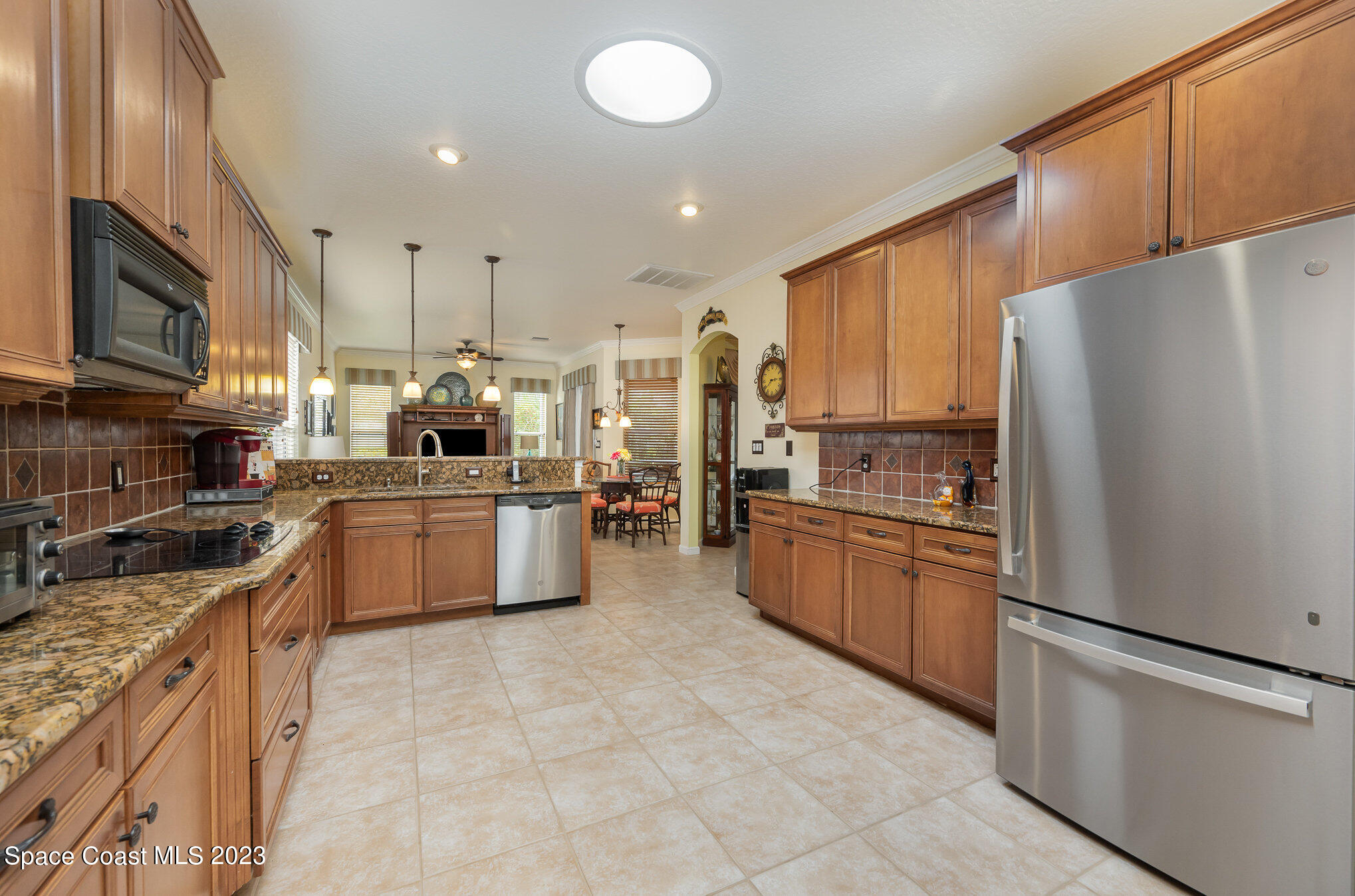 6972 Premonition Drive Melbourne, FL 32940 - Photo 13 of 33 a large kitchen with stainless steel appliances lots of counter top space cabinets and a refrigerator