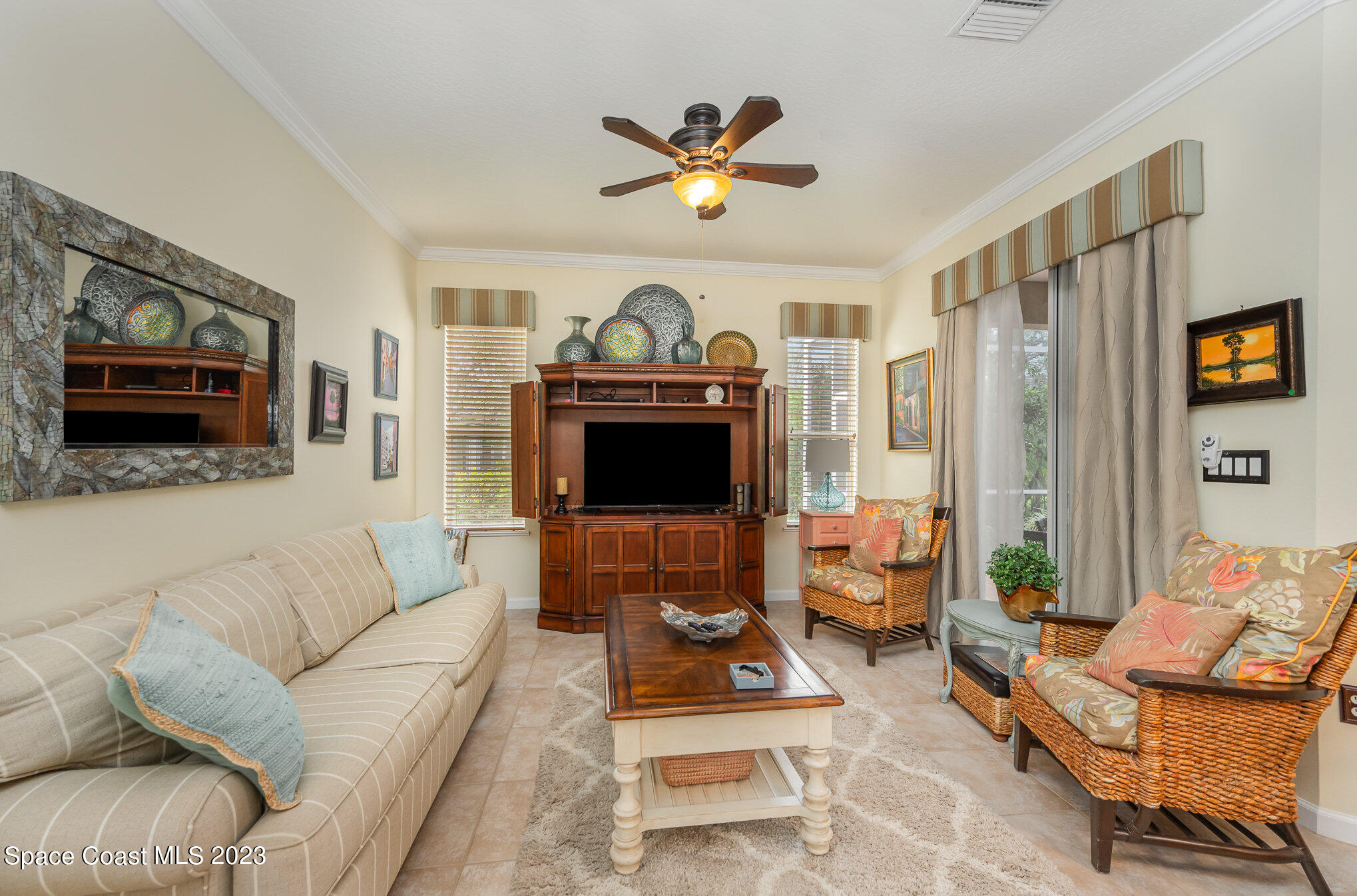 6972 Premonition Drive Melbourne, FL 32940 - Photo 15 of 33 a living room with furniture a flat screen tv and a fireplace