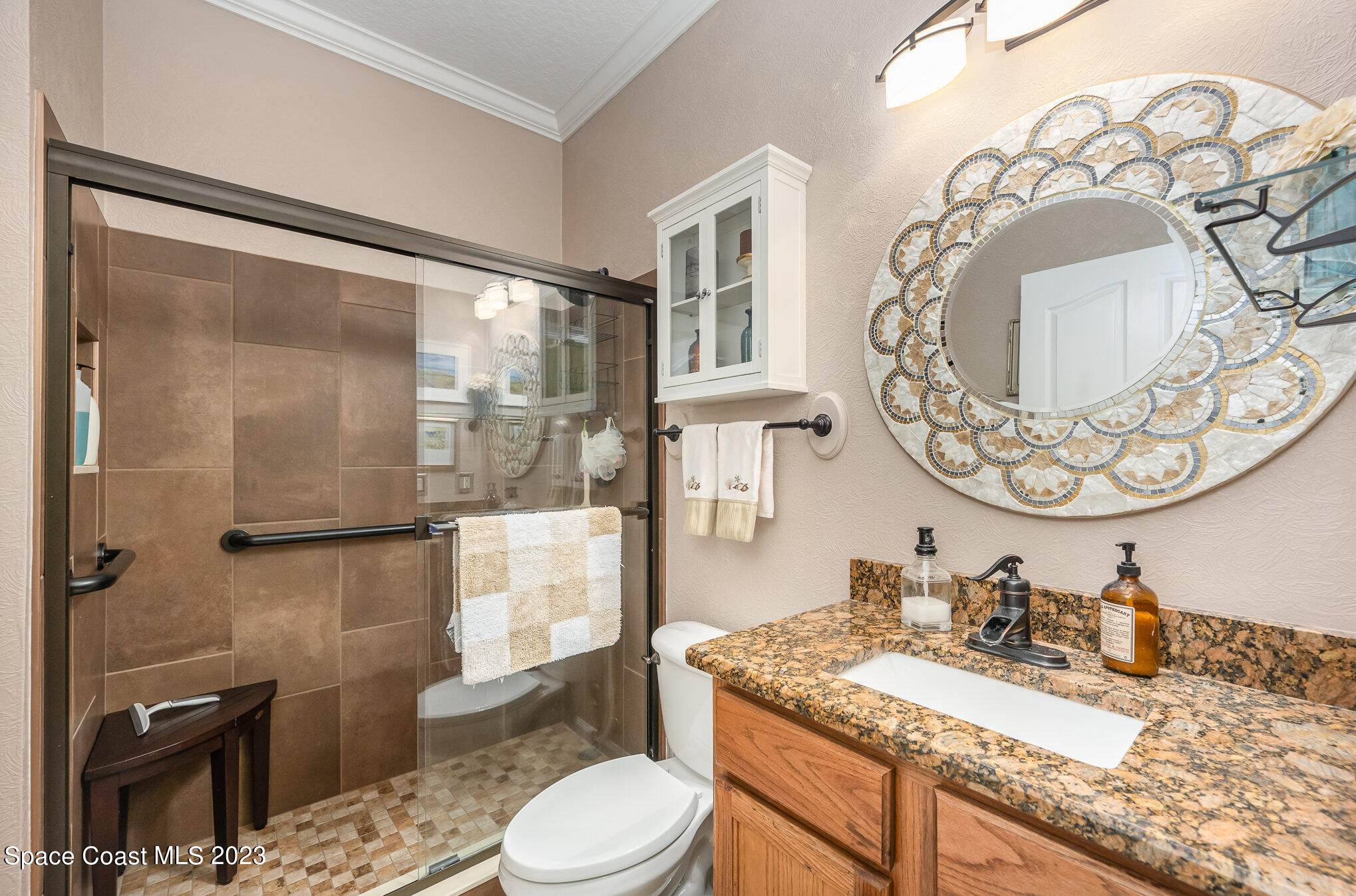 6972 Premonition Drive Melbourne, FL 32940 - Photo 24 of 33 a bathroom with a granite countertop sink mirror vanity and toilet