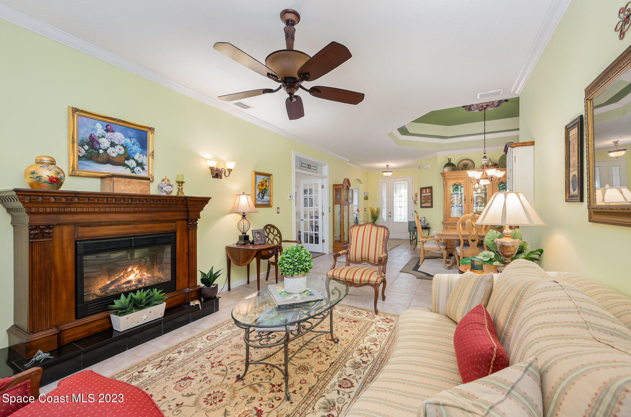 6972 Premonition Drive Melbourne, FL 32940 - Photo 9 of 33 a living room with furniture a fireplace and a chandelier
