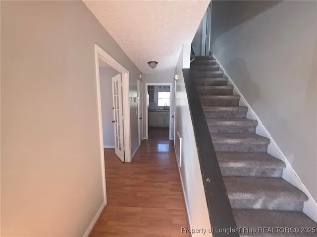a view of a hallway with wooden floor and entryway