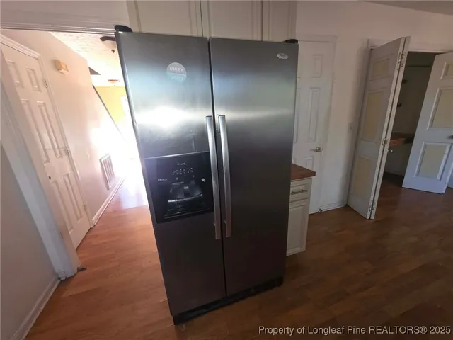 a view of hallway with stainless steel appliances wooden floor
